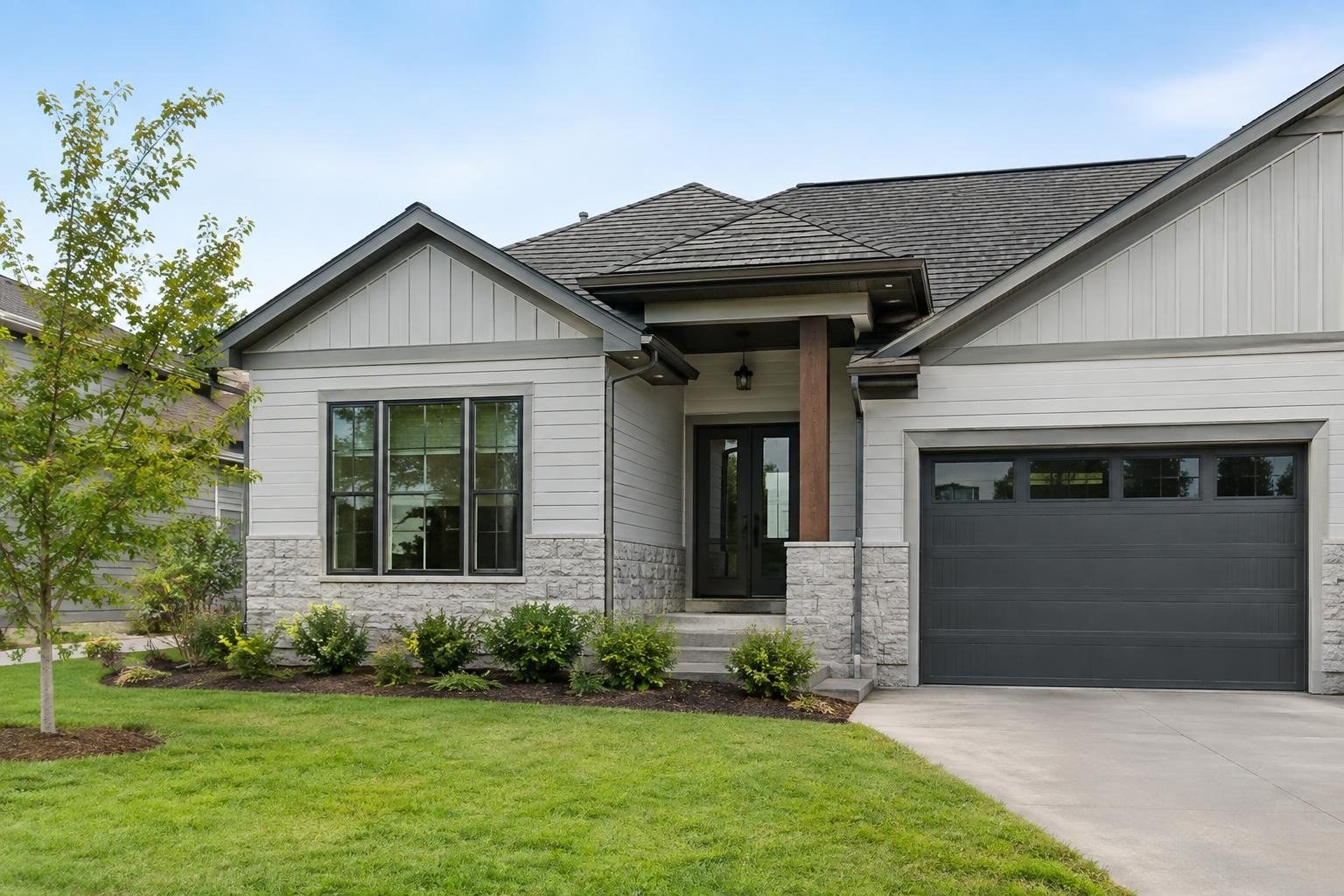 Side-by-side illustration of a house manager coordinating a household and a property manager handling rental operations A light-colored house with a dark garage door, front windows, stone lower walls, and a covered entrance stands behind a lawn and landscaped shrubs.